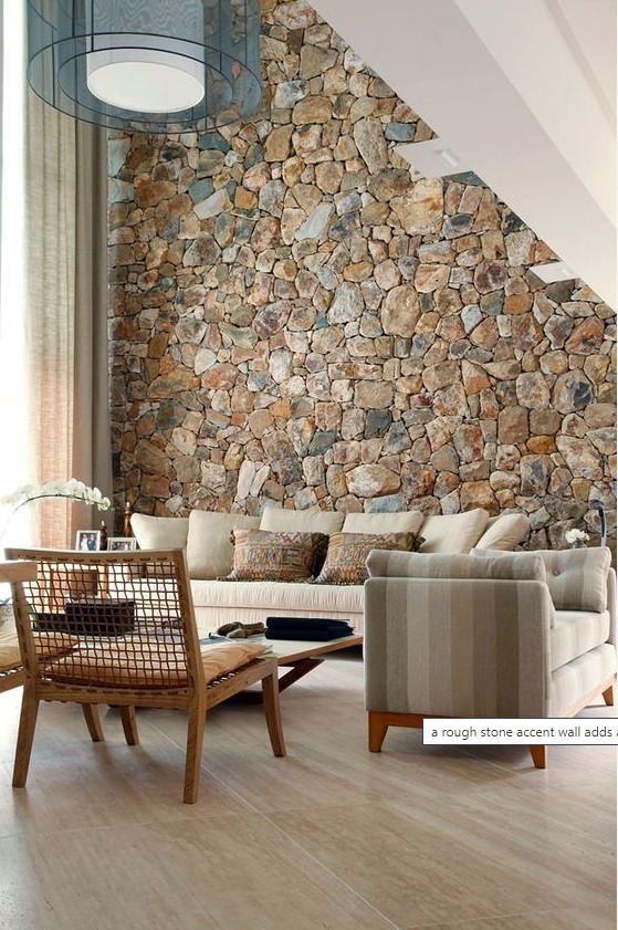 a rough stone accent wall adds a natural feel to the contemporary living room and brings a touch of natural color