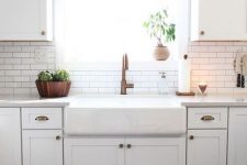 20 a white modern farmhouse kitchen with white skinny tiles and black grout on the backsplash and copper touches here and there
