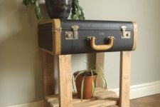 21 a black vintage suitcase placed on wooden legs, with a wooden shelf is a lovely console table and plant stand at the same time