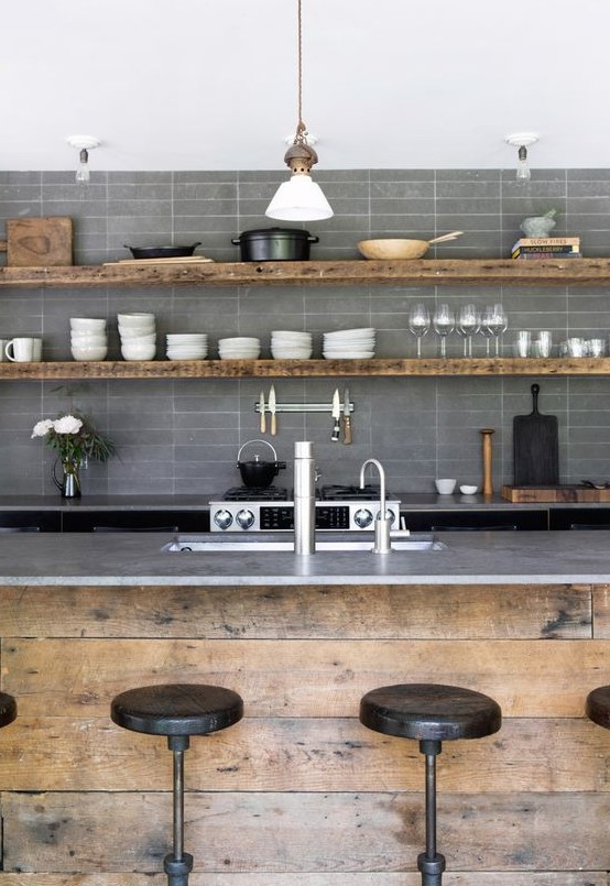 an industrial kitchen with matte grey skinny tiles, rough wood furniture and pendant lamps