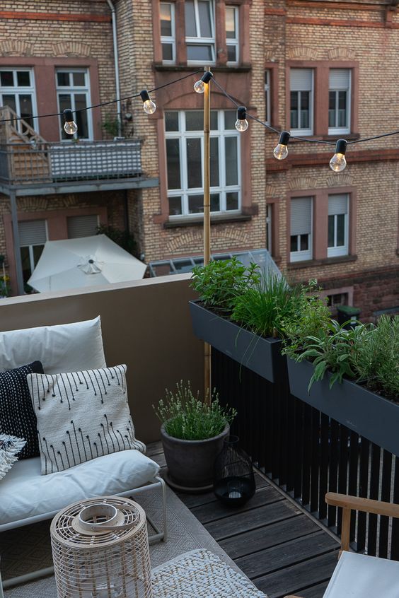 black planters hanging on the railing save your floor space and make the balcony look fresh and garden-like