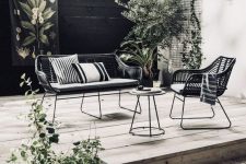 24 a Scandinavian outdoor space with elegant metal and wicker furniture, wooden decks and potted greenery and a tree