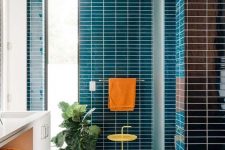 25 a bold bathroom clad with blue skinny tiles, with a floating white vanity and orange towels is an amazing space infused with color