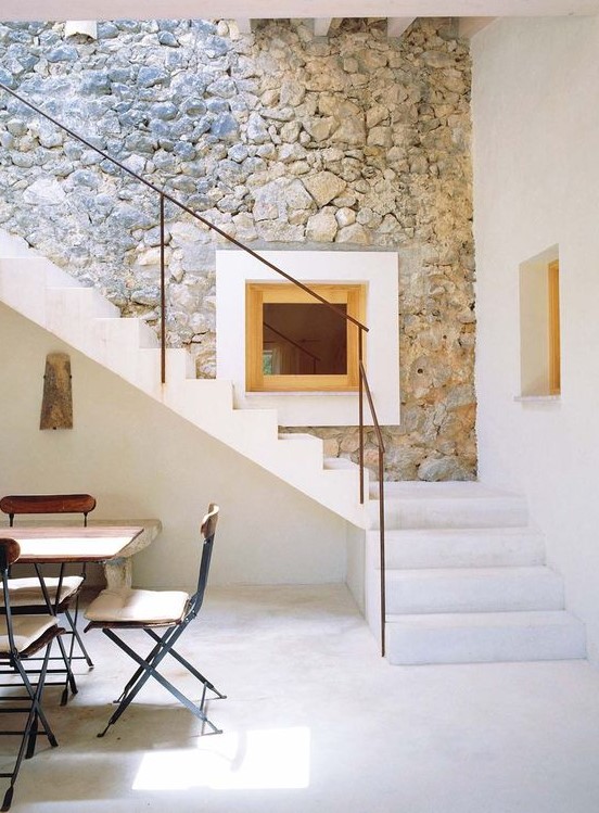 a contemporary space with a real stone accent wall - an original feature that was preserved and made outstanding