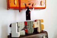 30 pretty shelves made of an orange and a brown suitcase piece that are used to display various decor on the wall