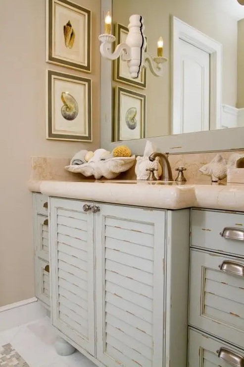 a sink vanity made of old pastel colored shutters and a stone countertop for a beach inspired bathroom
