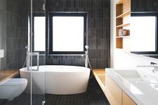 32 a contemporary bathroom all clad with matte dark skinny tiles and refreshed with light colored wood and white pieces