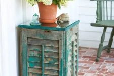 33 an outdoor side table of old shutters and a couple of wooden planks, the aged look fo the shutters is highlighted