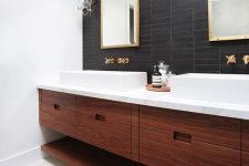 37 a mid-century modern bathroom with black skinny tiles on the accent wall that contrast white sinks