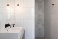 39 a minimalist bathroom done with grey tiles and white skinny ones for an eye-catchy touch