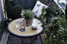 40 a monochromatic balcony with chairs and a lot of potted greenery is spruced up with a colorful mosaic table