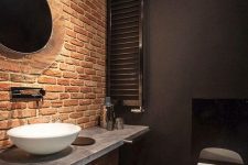 an industrial bathroom design with a brick wall