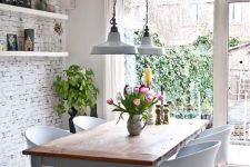 41 a modern Nordic dining room with a whitewashed brick wall, a modern dining set and vintage lamps and potted plants