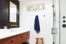 42 a welcoming mid-century modern bathroom with black and white tiles, a shower space, a double stained vanity, metallic fixtures