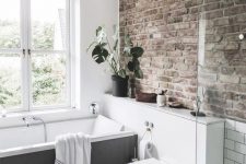 43 a neutral contemporary bathroom done with a single brick wall that adds character and style to the space