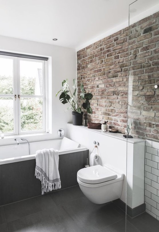 a neutral contemporary bathroom done with a single brick wall that adds character and style to the space