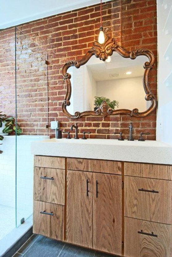 a wall partly done with red brick makes the bathroom more eye catchy, a bit industrial and cool