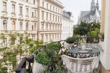 46 a Scandinavian balcony with a striped rug, white chairs and a black coffee table, potted greenery and fantastic views of Vienna