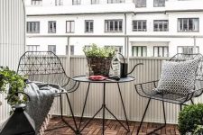 50 a stylish Scandinavian balcony with black metal chairs and a coffee table, candle lanterns and potted plants is a very stylish idea for a Nrodic style lover