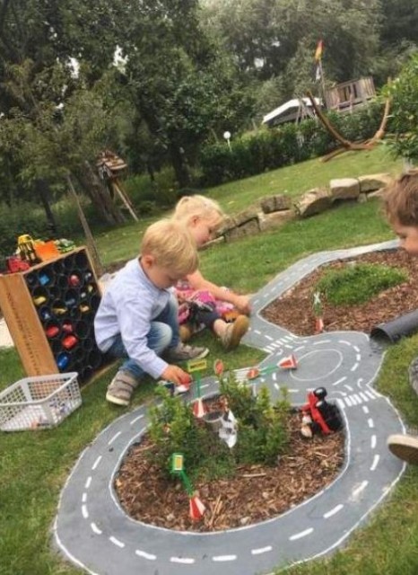 a backyard play area with race tracks will attract both girls and boys and you may add some plants and blooms there