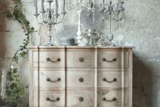 a beautiful light-stained wood vintage dresser with antique candlabras and accessories is a lovely piece for many living rooms and bedrooms