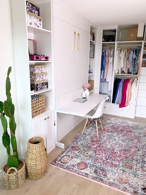 a chic white cloffice with open and closed storage units, a small retractable desk and a white chair, some baskets for storage