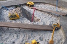 a construction site gravel pit with bold toys and showvels is a fun and cool idea for an outdoor space, a gravel pit is always a good idea
