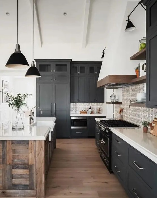 a contemporary barn kitchen with graphite grey shaker style cabinets, white stone countertops, a reclaimed wood kitchen island and black lamps