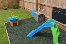 a cool play area with a mud kitchen, a chalkboard, colorful bug pebbles and a bright slide is a nice idea for outdoors