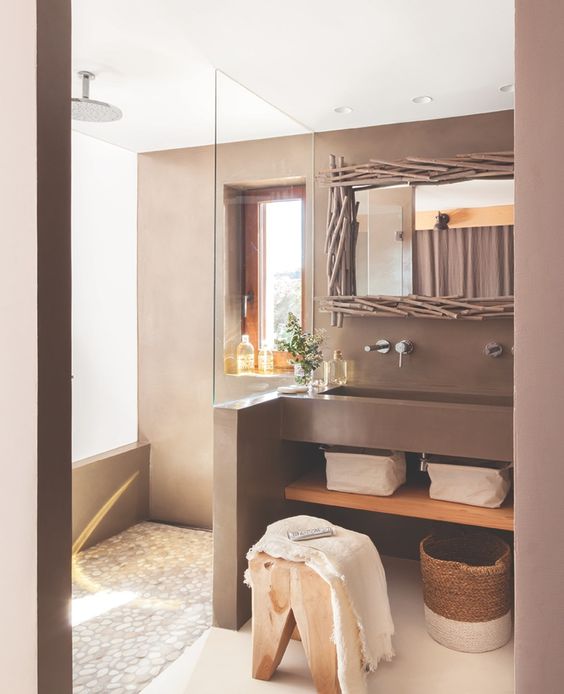 a creative and lovely brown bathroom with a mirror in a stick frame, a large brown built in sink and a wooden sotol