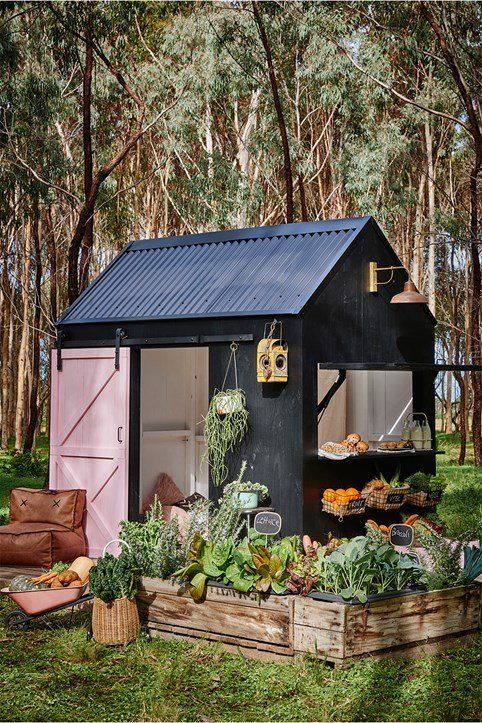 a cute kids' cabin in black with leather pillows and cushions, crates with various veggies and herbs to play grocery store