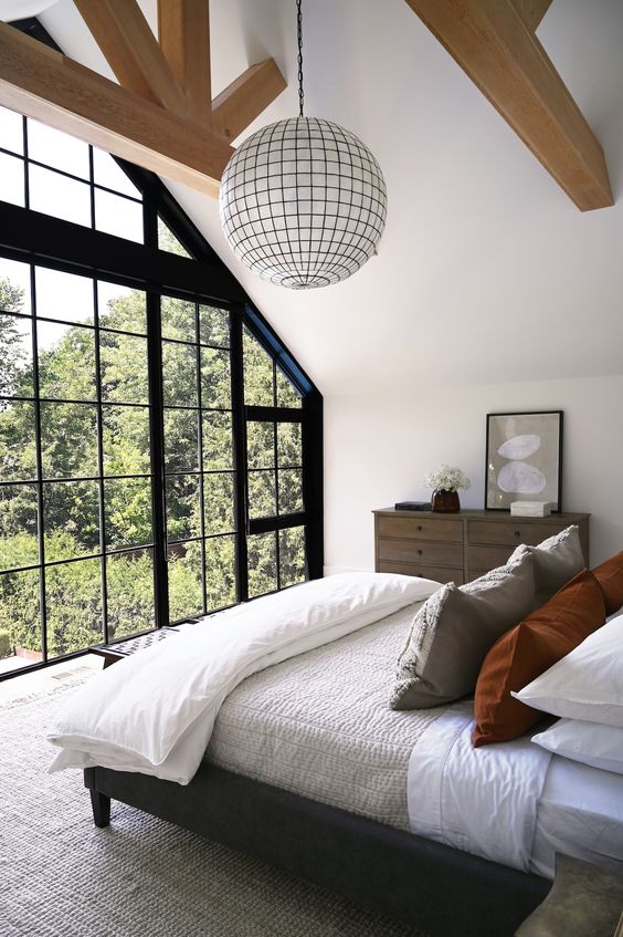 a large floor to ceiling window that repeats the look of the house and lets for gorgeous forest views that relax at once