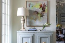 a light grey vintage dresser with shaker style doors and oversized gold knobs is a chic solution for an entryway and not only