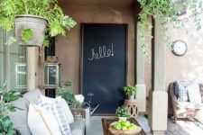 a modern country terrace with woven furniture, potted greenery, printed textiles and a chalkboard is a lovely and welcoming space
