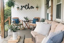 a modern farmhouse terrace with stained rockers, a wicker sofa, a shabby chic coffee table and potted plants
