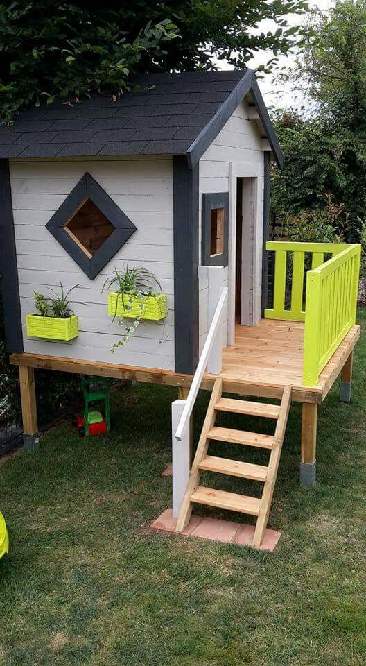 a modern kids' playhouse in black and white, with neon yellow planters attached to the wal and railing is a stylish idea
