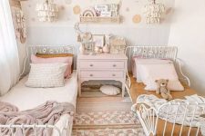 a pastel boho shared bedroom with metal beds, pastel and mustard bedding, boho rugs, a pink dresser and tassel pendant lamps
