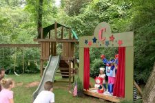 a pretty and fun outdoor backyard kids’ theater with a scene, a slide and some benches for watching plays