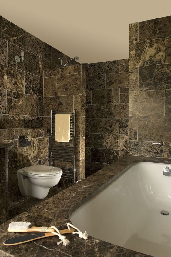 a refined brown marble bathroom with a bathtub clad with tiles is a very chic and sophisticated space