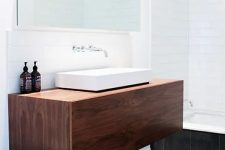 a rich-stained floating vanity with a square sink and some bottles will provide you with storage space and won’t take any floor space