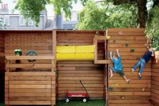 a simple sports ground of wood, with a green lawn, climbing walls and a space to play pirates