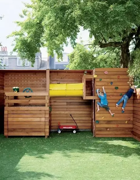 a simple sports ground of wood, with a green lawn, climbing walls and a space to play pirates