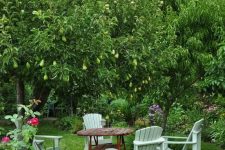 a small and cool dining eating area with a simple wooden table and chairs under pear trees and on grass is a cool idea