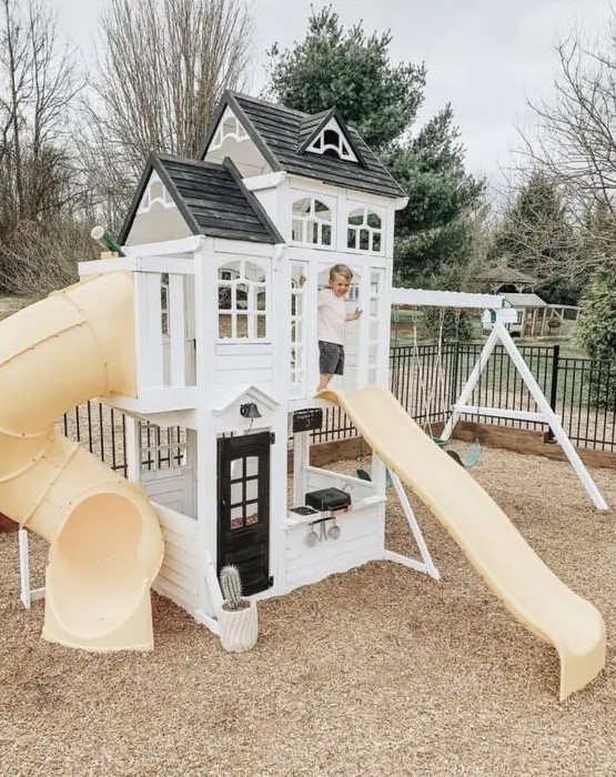 a small black and white playhouse with two slides and swings is a lovely idea for a modern farmhouse garden