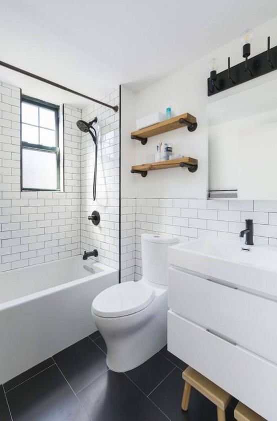 a small minimalist bathroom with white subway tiles, a white vanity, open shelves and touches of black to make the space look contrasting