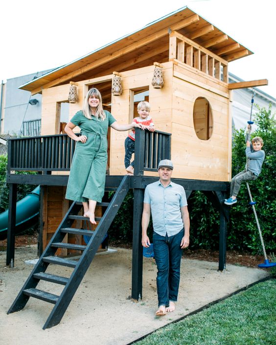 a stylish modern kids' playhouse with ladder, rope, railing and some play space inside the house is a cool idea for your backyard