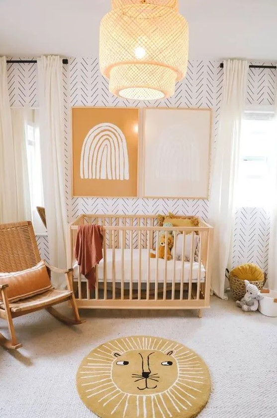 a warm colored mid century modern meets boho nursery with printed wallpaper, stained furniture, layered rugs, mustard pillows, a woven pendant lamp