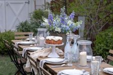 a welcoming dining zone with a wooden table and wooden and metal chairs, neutral linens and blooming trees aroun
