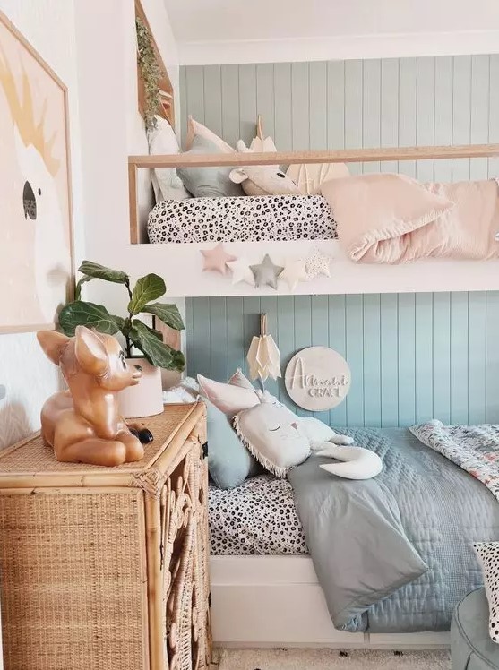 an amazing shared girls' bedroom with a blue accent wall, a bunk bed with blue and pink bedding, a woven storage cabinet