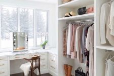 an ethereal cloffice with a large white open closet and a built-in desk or vanity table plus a gorgeous view